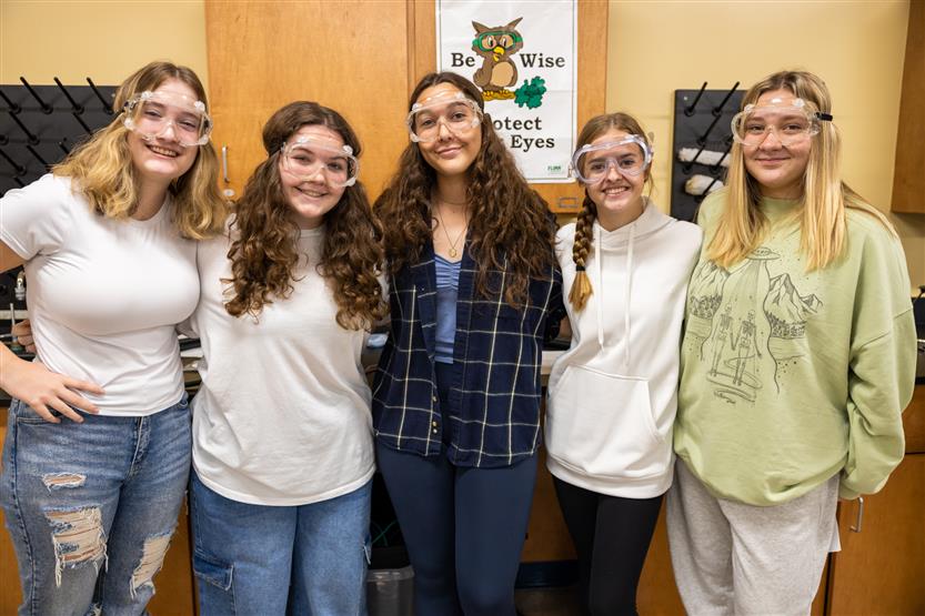 A group of students smile in a science lab